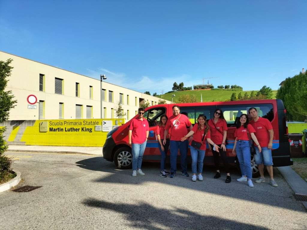 Foto gruppo scuola AVIS Moie con pulmino davanti alla scuola primaria di Moie